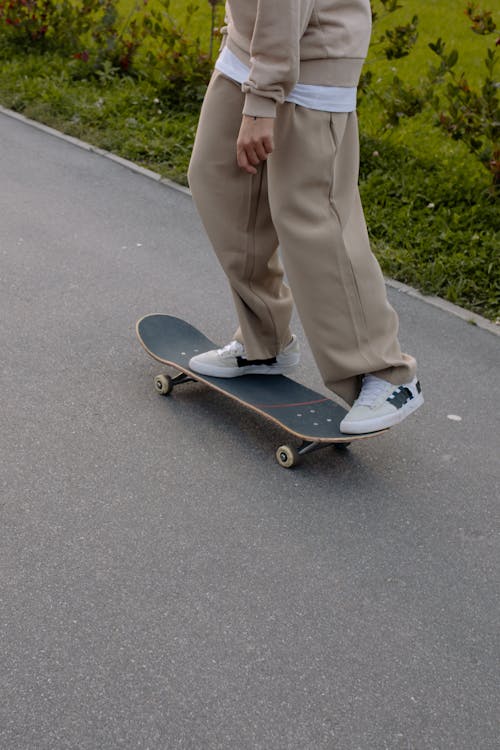 Foto stok gratis anonim, bermain skateboard, celana krem