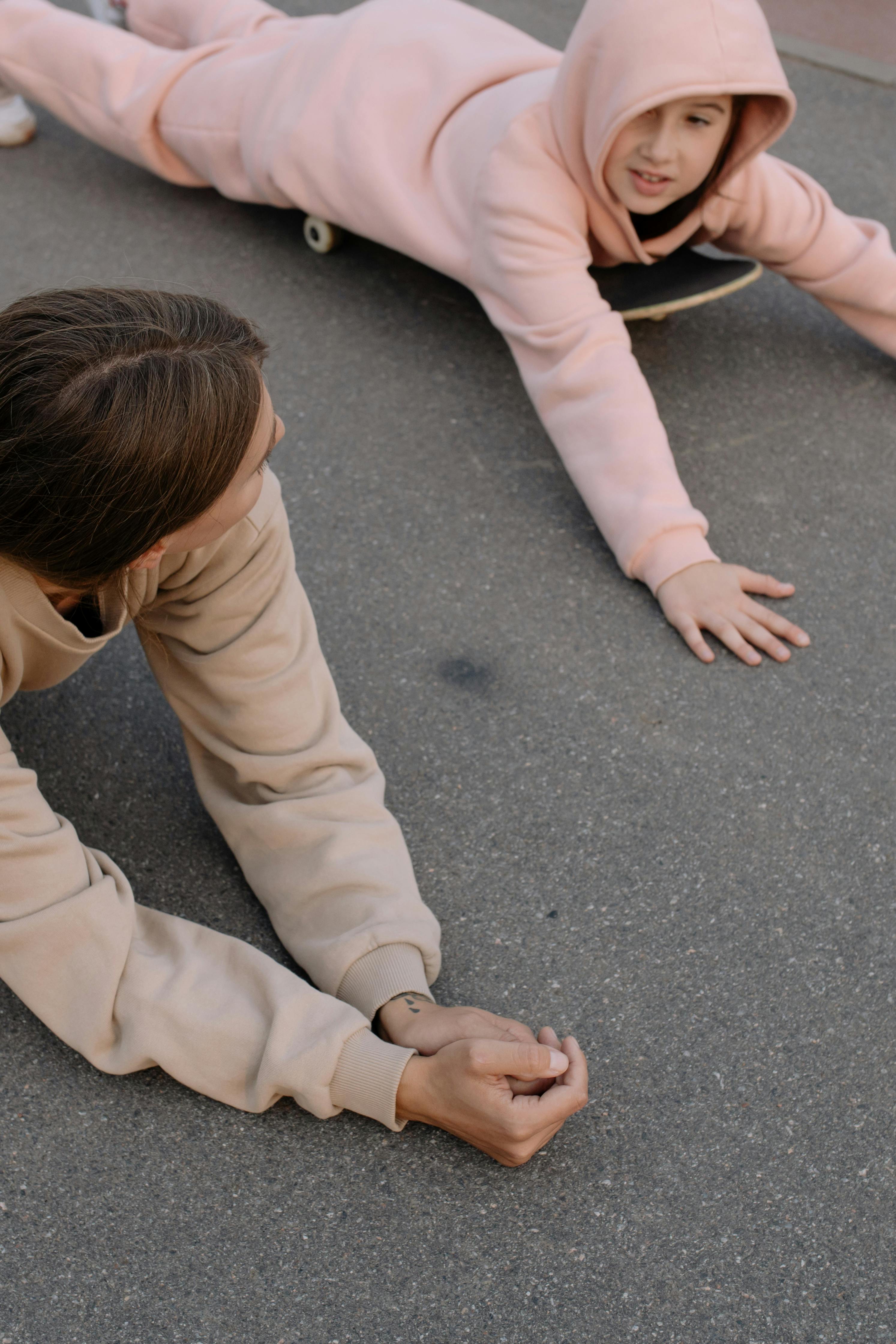 teenage girls lying on skateboards on asphalt