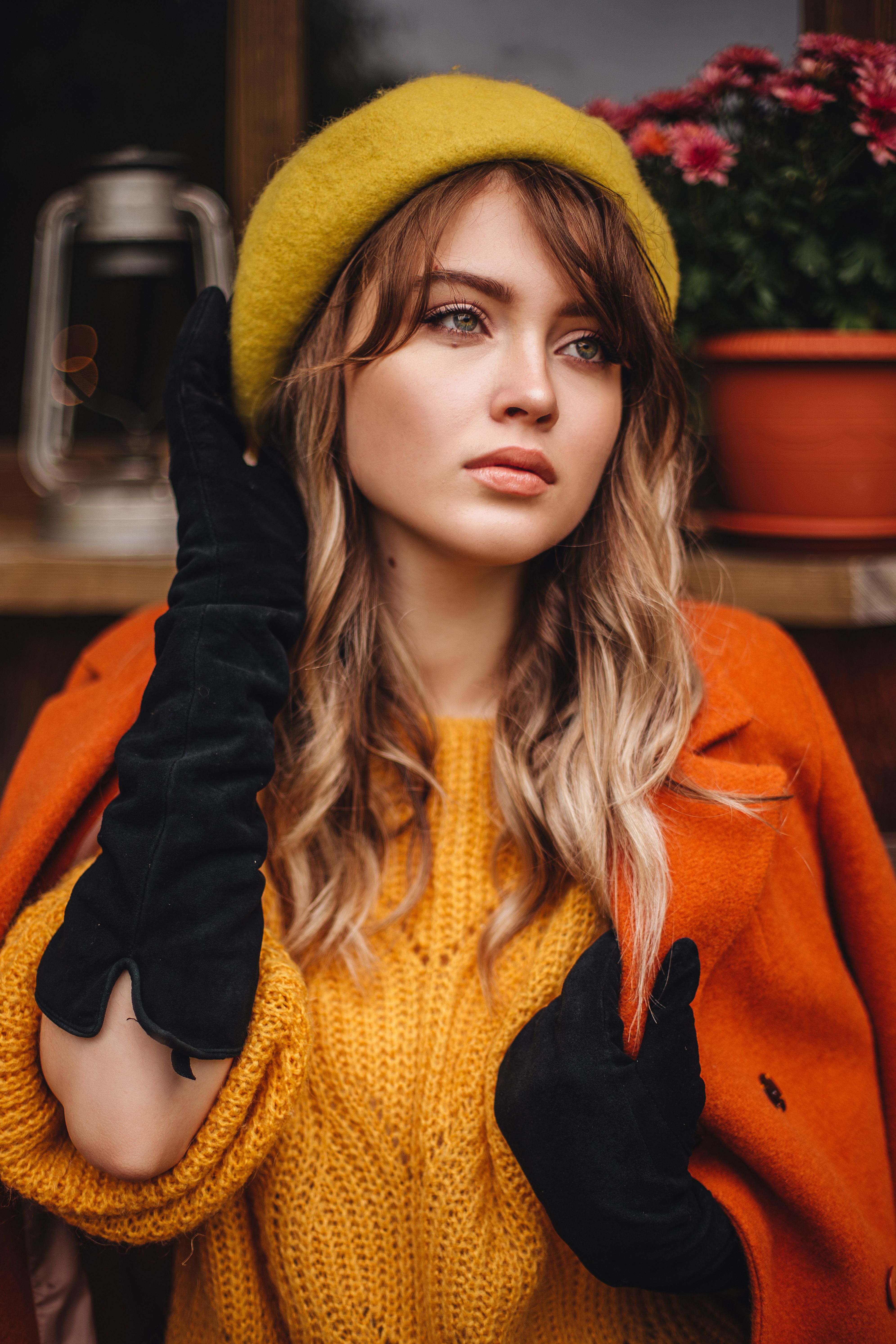 Stylish woman in autumn attire with a yellow beret and orange coat.