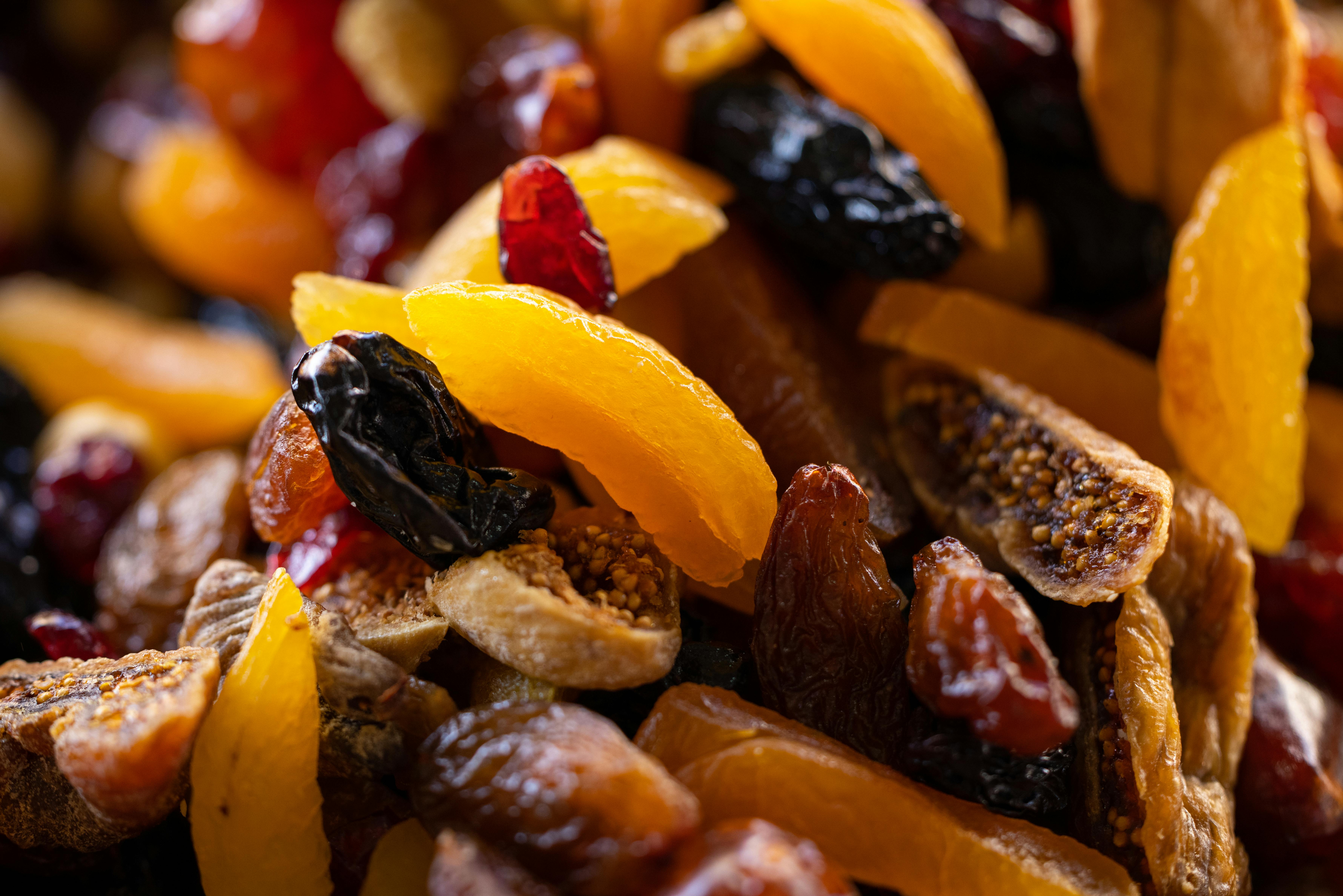 Colorful close-up of assorted dried fruits like figs, apricots, and raisins, showcasing texture.