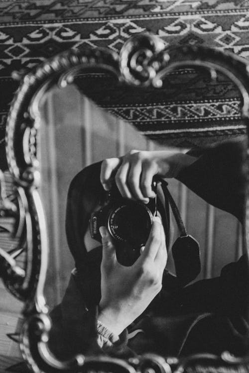 Grayscale Photo of a Person Taking Photo with a Camera