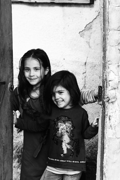 A Grayscale Photo of Two Girls Smiling