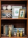 复古书架配有古董书籍、装饰框架和金瓶子，营造出精致的室内氛围