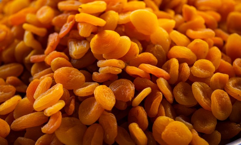 Damascos secos laranjas em close-up mostrando a textura e cor características da fruta desidratada