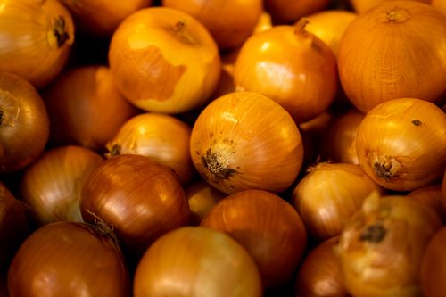 Free A vibrant close-up of fresh raw onions piled together, showcasing their natural texture and colors. Stock Photo