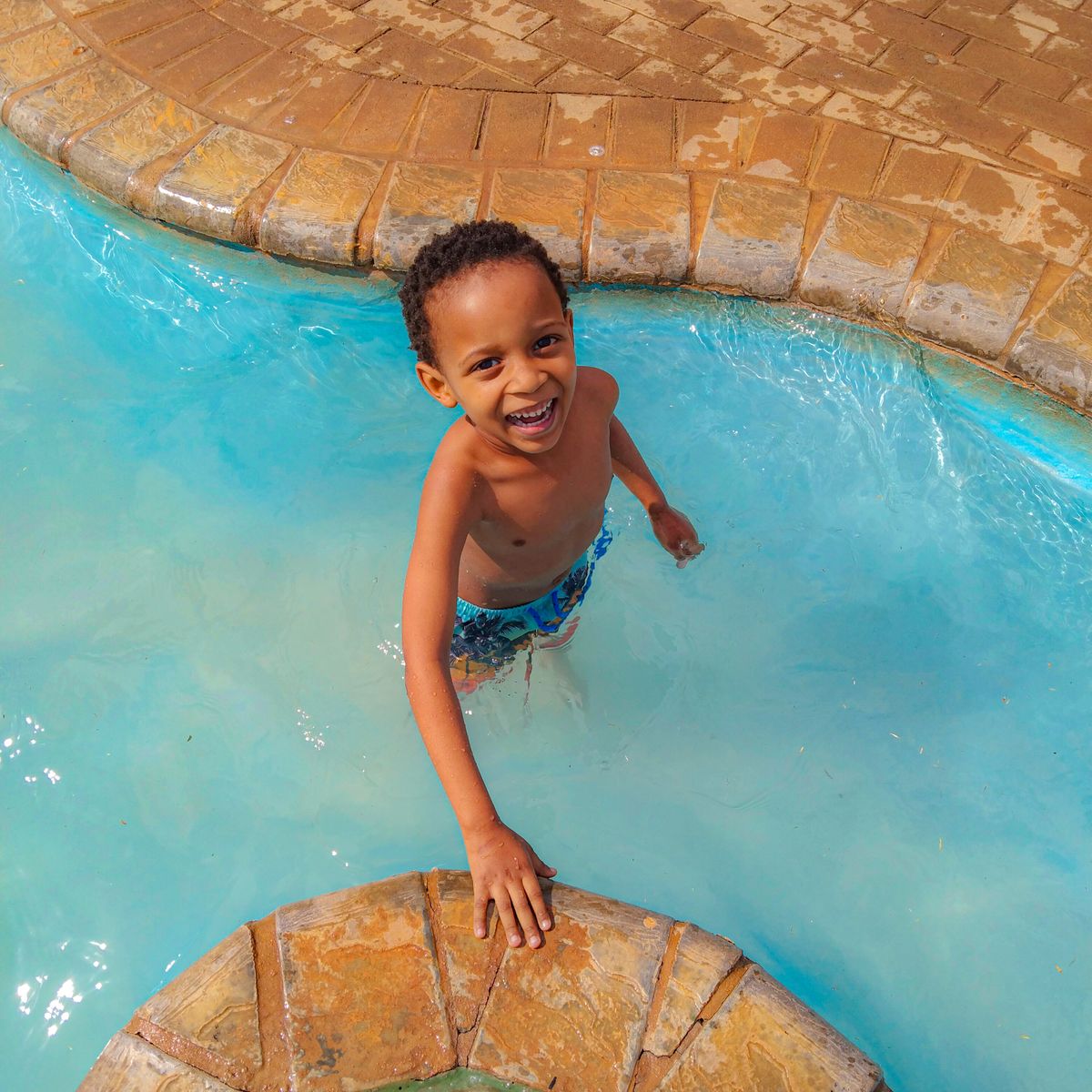 Kid playing pool party games in a swimming pool