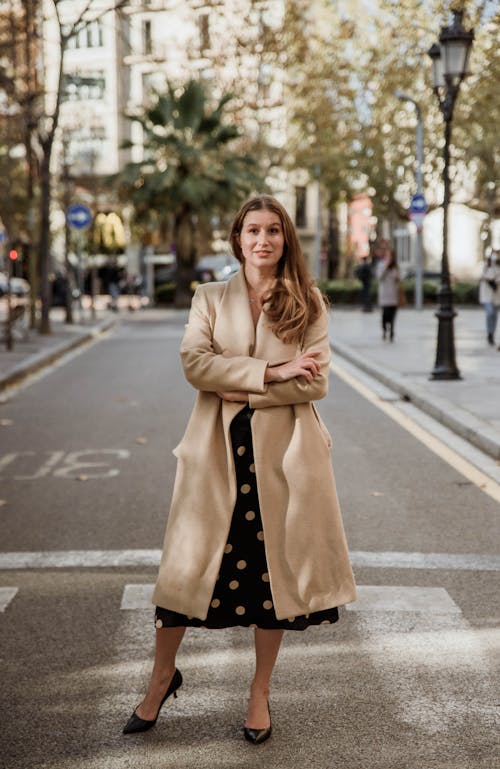 A Woman Standing on the Street Wearing a Trench Coat