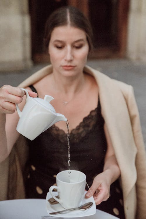 Woman Pouring Water to Glass