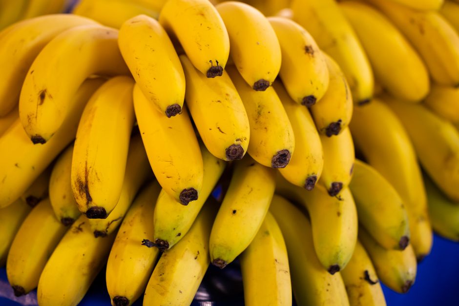 Cluster of bright yellow bananas stacked in a market