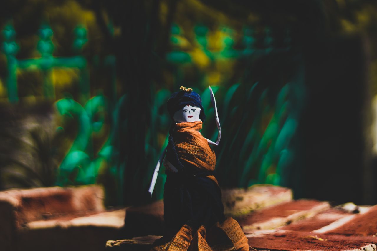 a handcrafted origami doll showcased in an outdoor setting capturing a