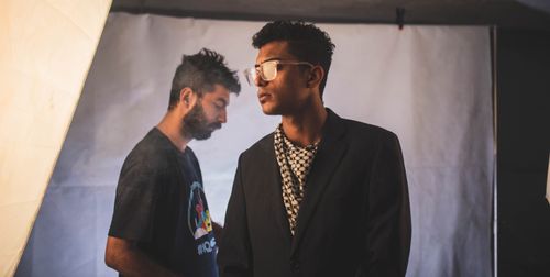 Free Two young men in a studio setting with stylish attire and professional lighting. Indoor atmosphere. Stock Photo