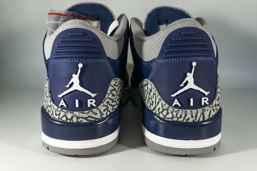 Close-up of blue and gray Air Jordan sneakers with iconic logo, showcasing trendy footwear design.