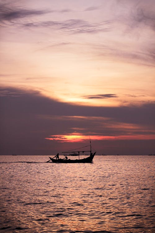 Silhouette of a Fishing Boat on Sea During Sunset