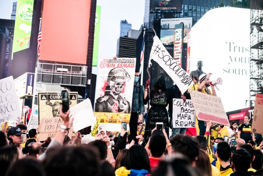 Large protest in Times Square, New York City highlighting political issues and freedom expression.
