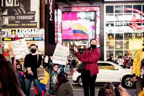 Free Colombian protesters in Times Square, New York, holding flags and placards for justice. Stock Photo