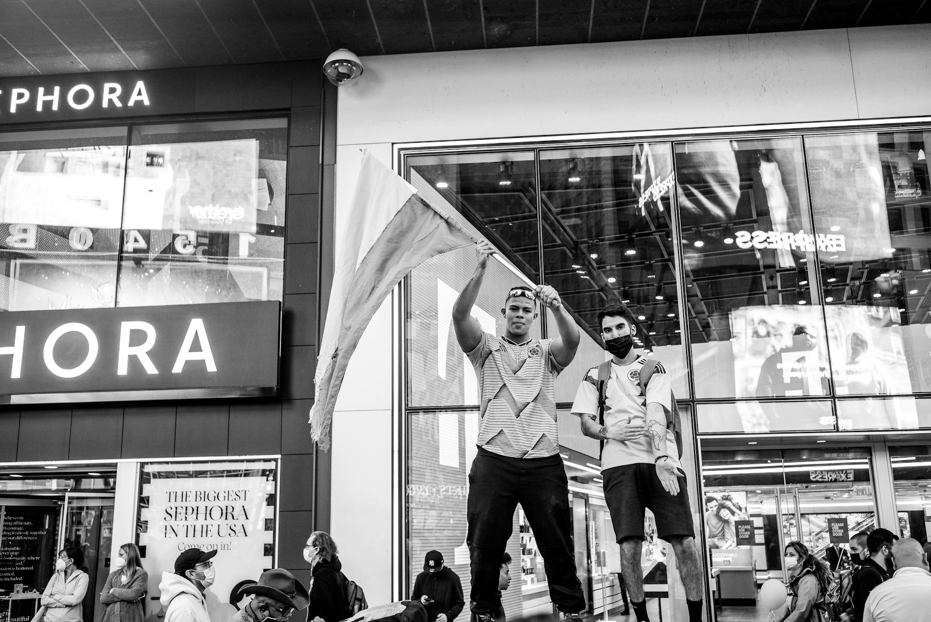 Black and white photo of a lively group outside Sephora in New York City.