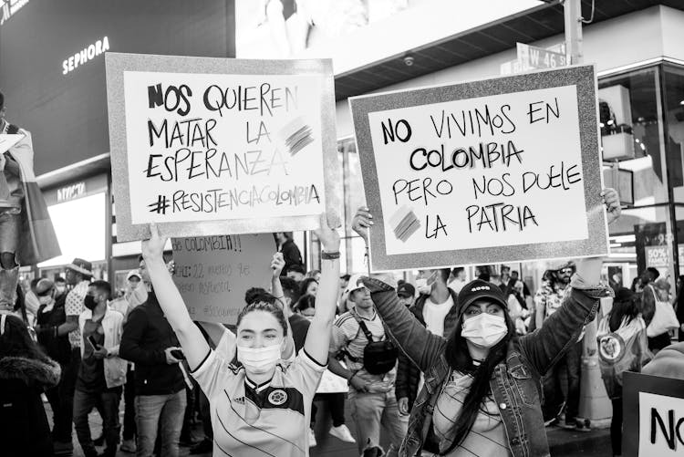 A Grayscale Of Women Protesting While Holding Signages