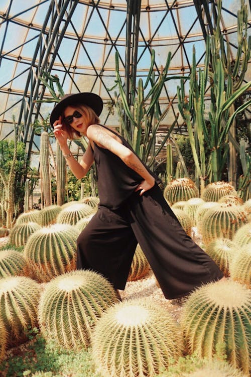 Woman Posing While Surrounded By Cactus Plants 