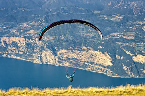 Free A Paraglider Flying Near the Mountains Stock Photo