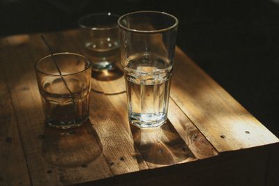 A glass of water on a pale wooden table — photo by Thới Nam Cao on Pexels