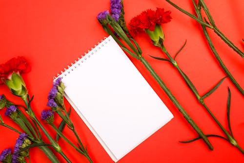Close Up Photo of Notepad and Flowers