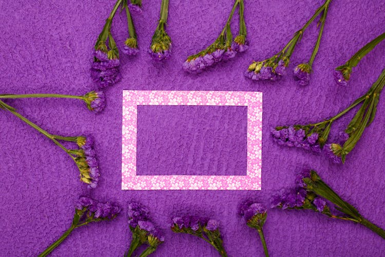 Empty Frame And Flowers On Purple Background 