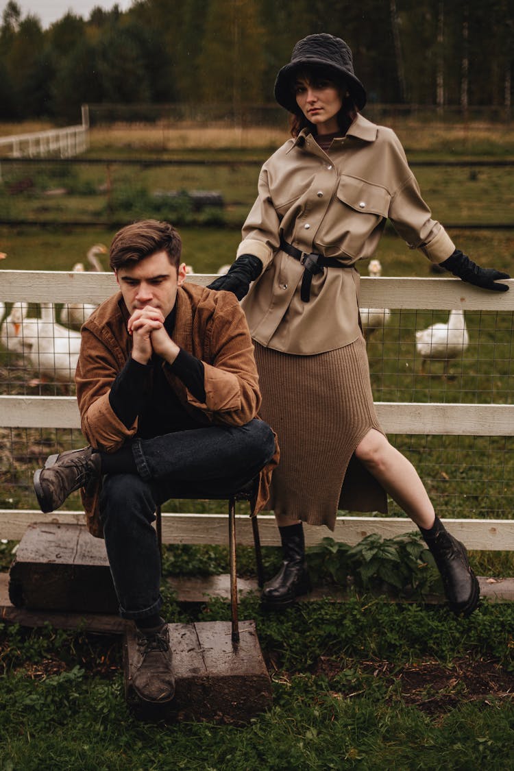  Man Sitting On Chair And Woman Standing Behind Him