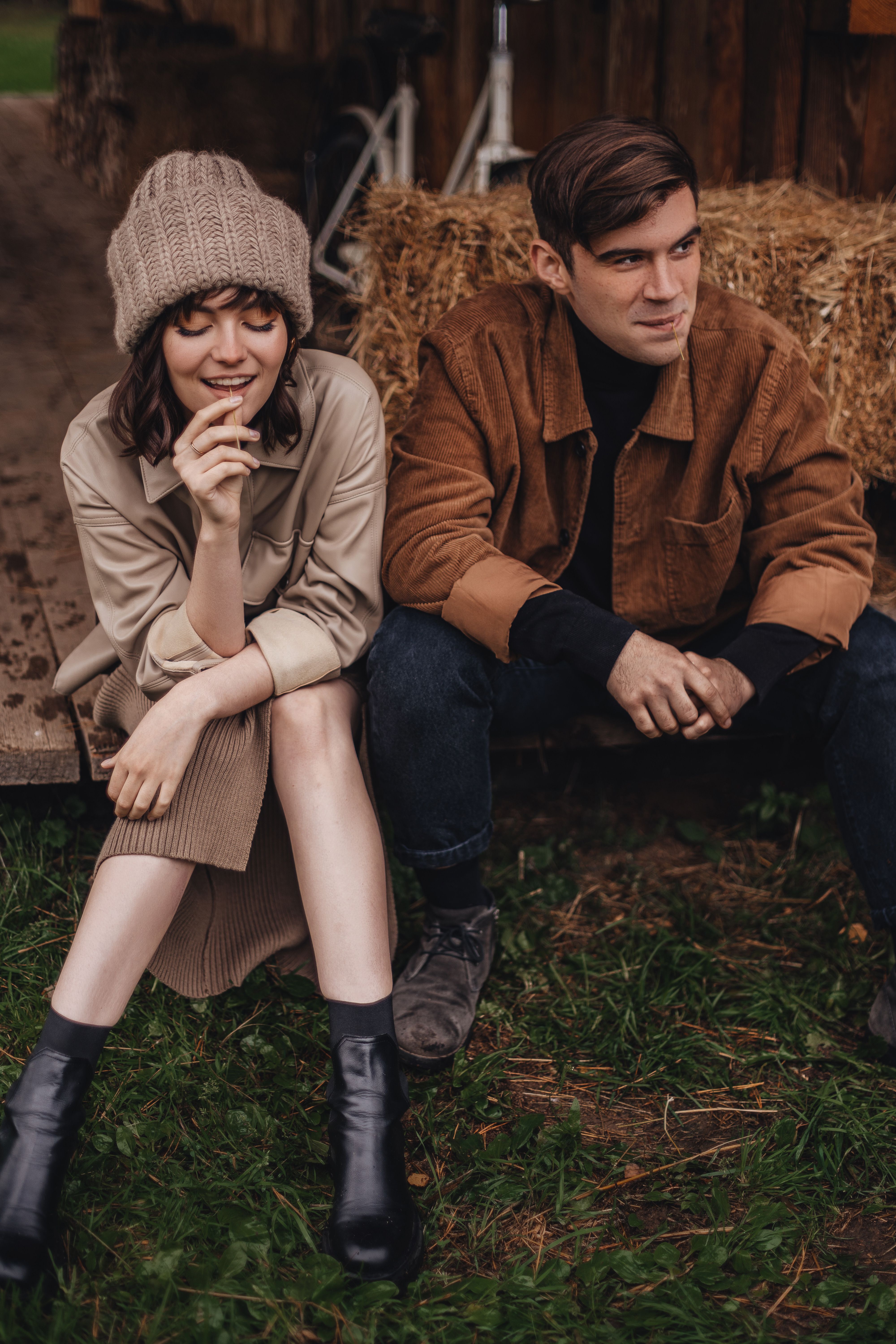 Young couple sitting together outdoors in Moscow, wearing fall clothing and enjoying the serene setting.