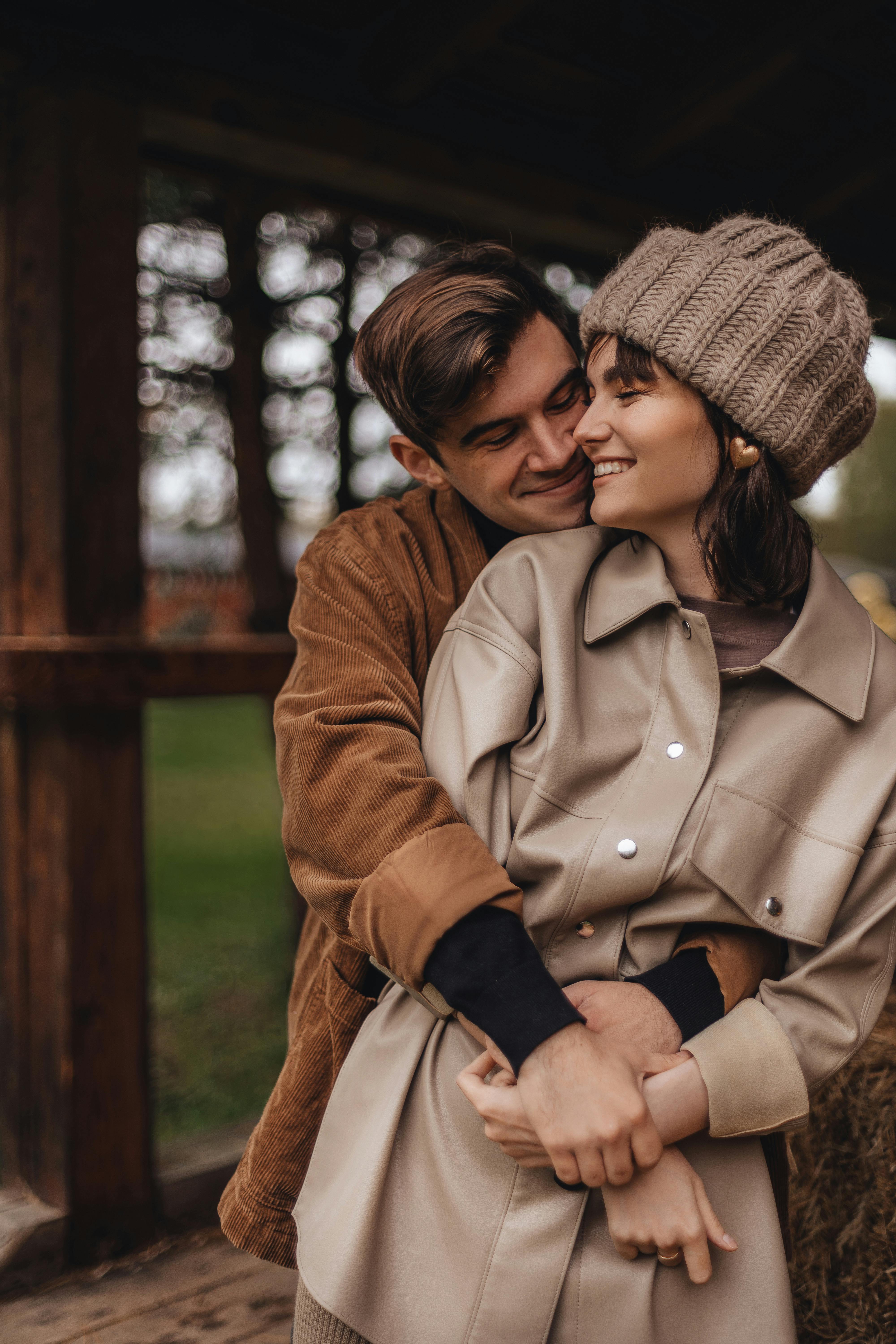 Loving couple embracing in warm clothing during a cool autumn day outdoors.