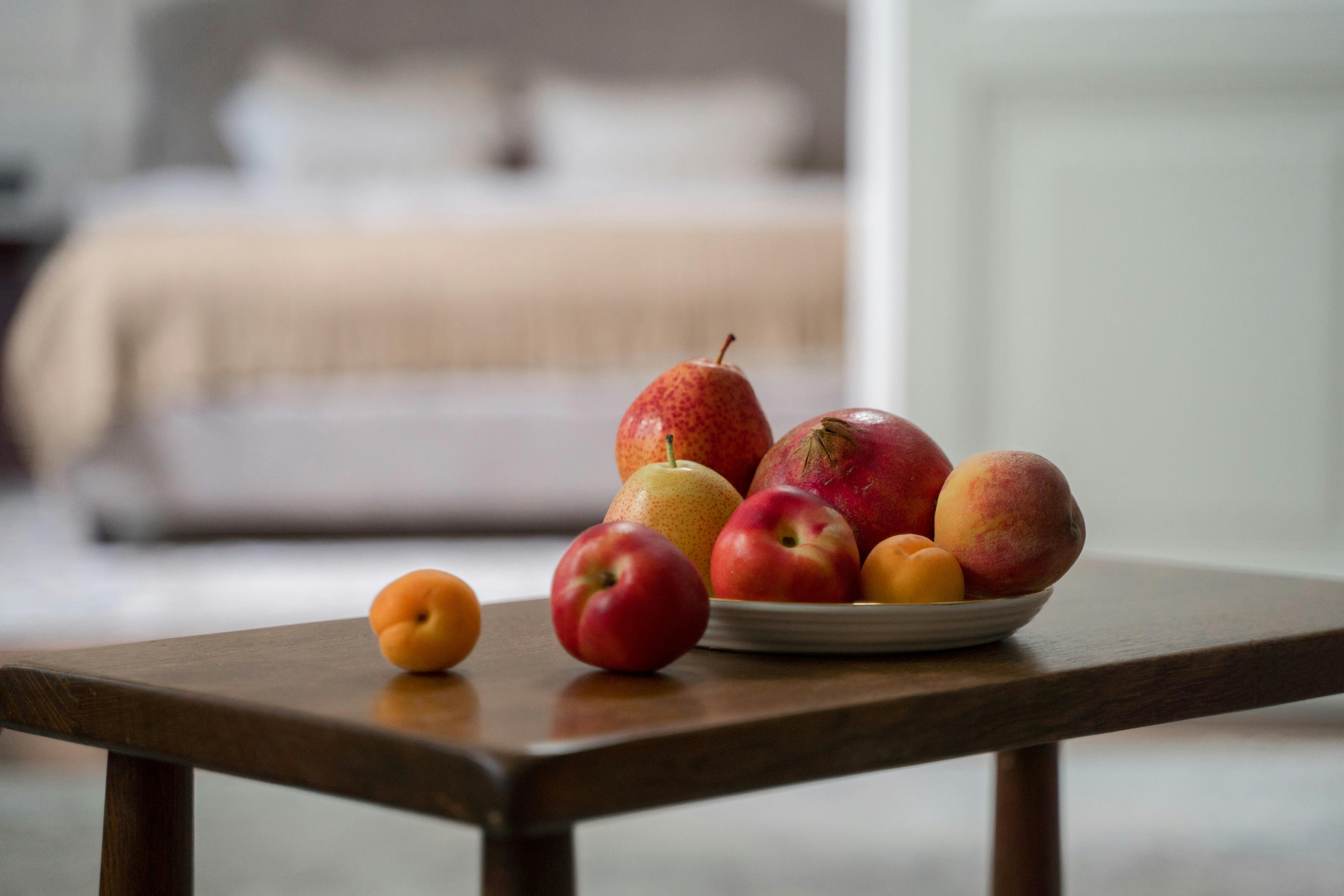 A beautiful arrangement of fresh peaches and heirloom tomatoes on a wooden table - what are summer fruits and vegetables