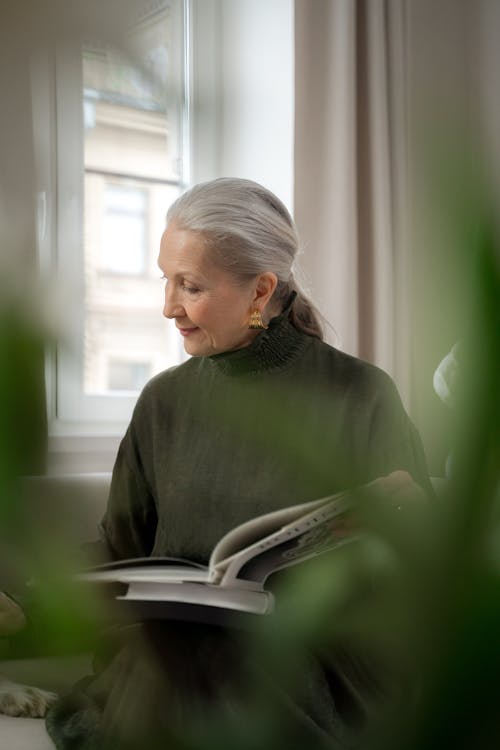 Free Senior Lady Reading Book at Home Stock Photo
