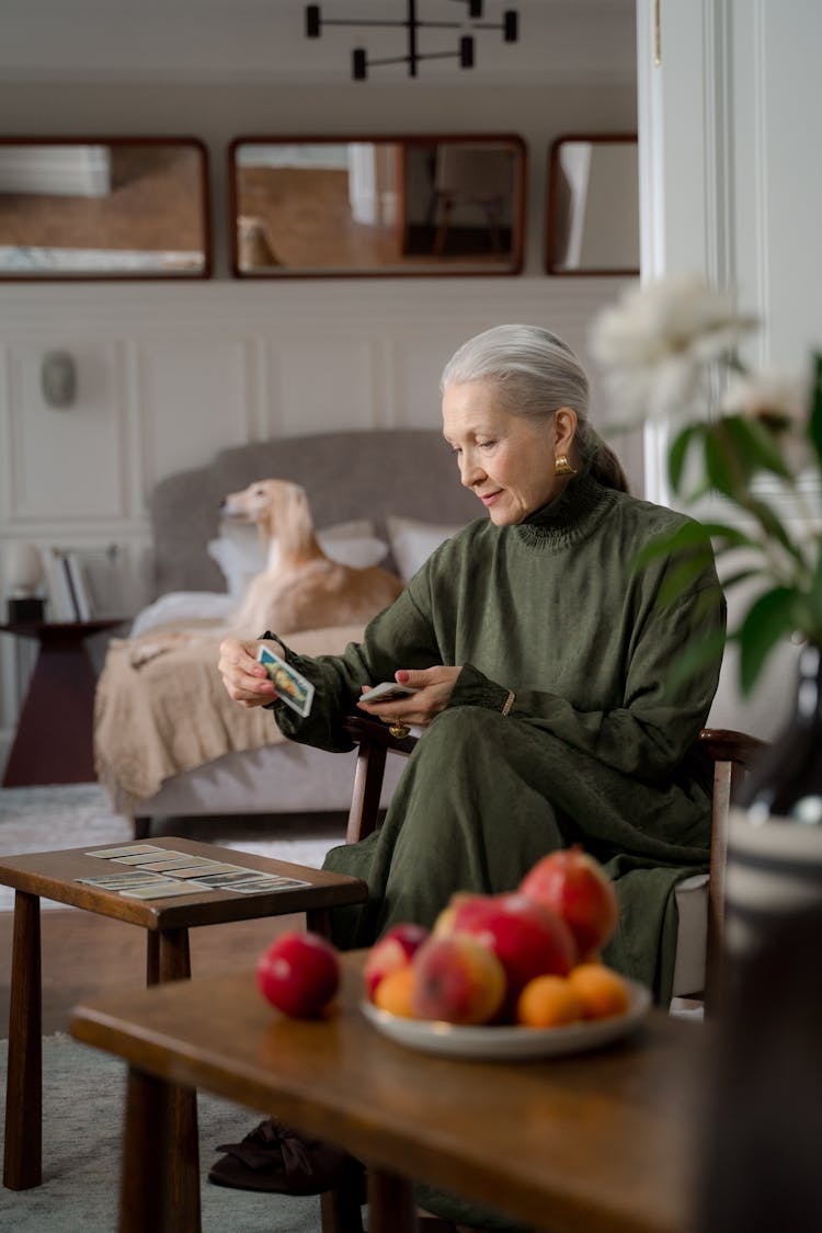 Elderly Woman Playing Cards And Her Dog In The Background