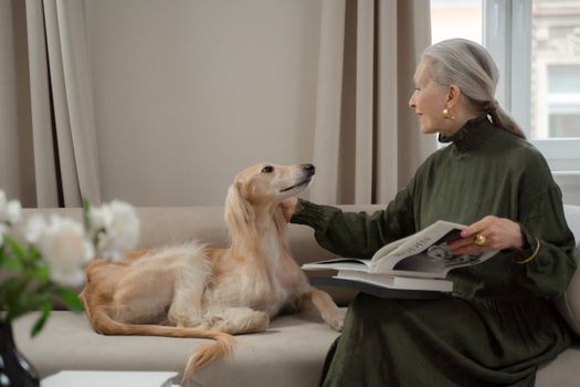 Senior Lady Talking to Her Dog Laying on Sofa