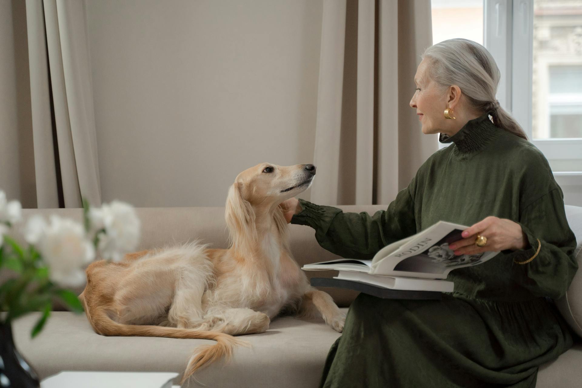 Senior Lady Talking to Her Dog Laying on Sofa