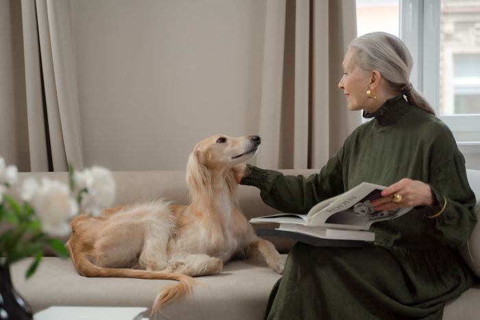 Senior woman relaxing at home on the sofa with her dog