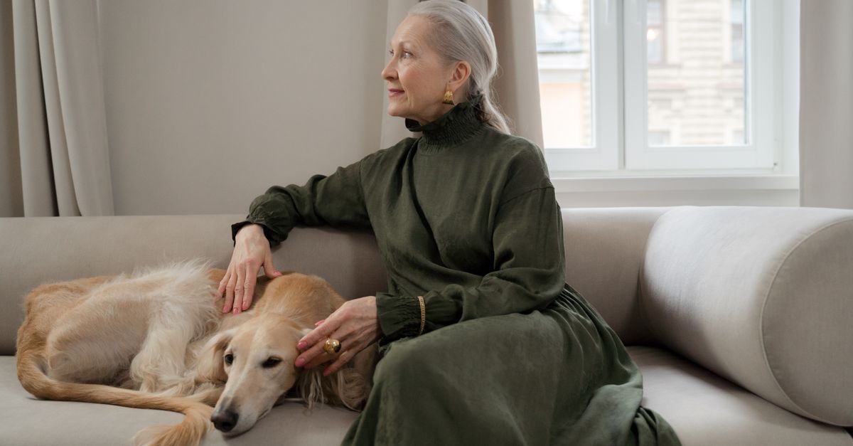 In-Home Pet Euthanasia Cost In-home pet euthanasia cost guide: an older woman gently stroking her dog on the sofa at home