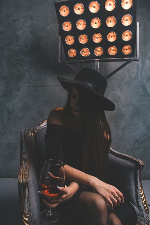 Woman in Black Tube Dress Sitting on Gray Armchair