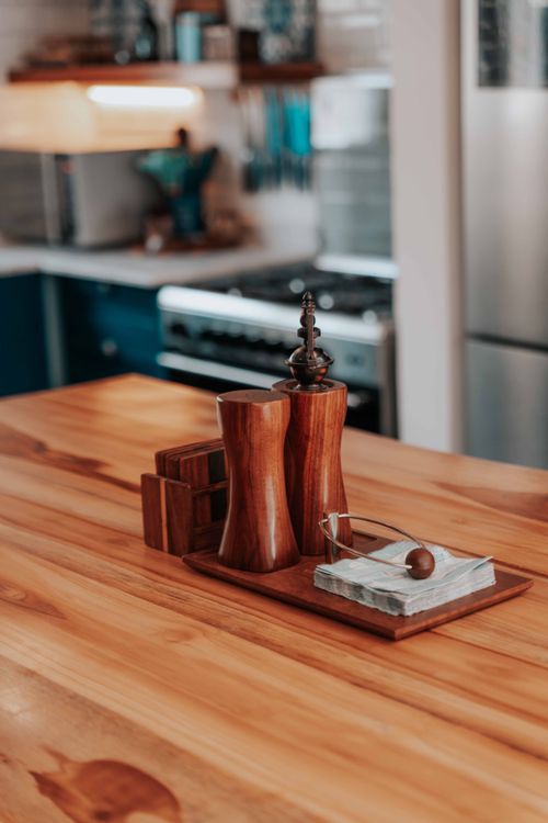 Free Elegant wooden salt and pepper shakers on a rustic kitchen table. Stock Photo