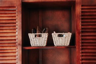 Two woven storage baskets on a painted shelf — photo by Keegan Checks on Pexels
