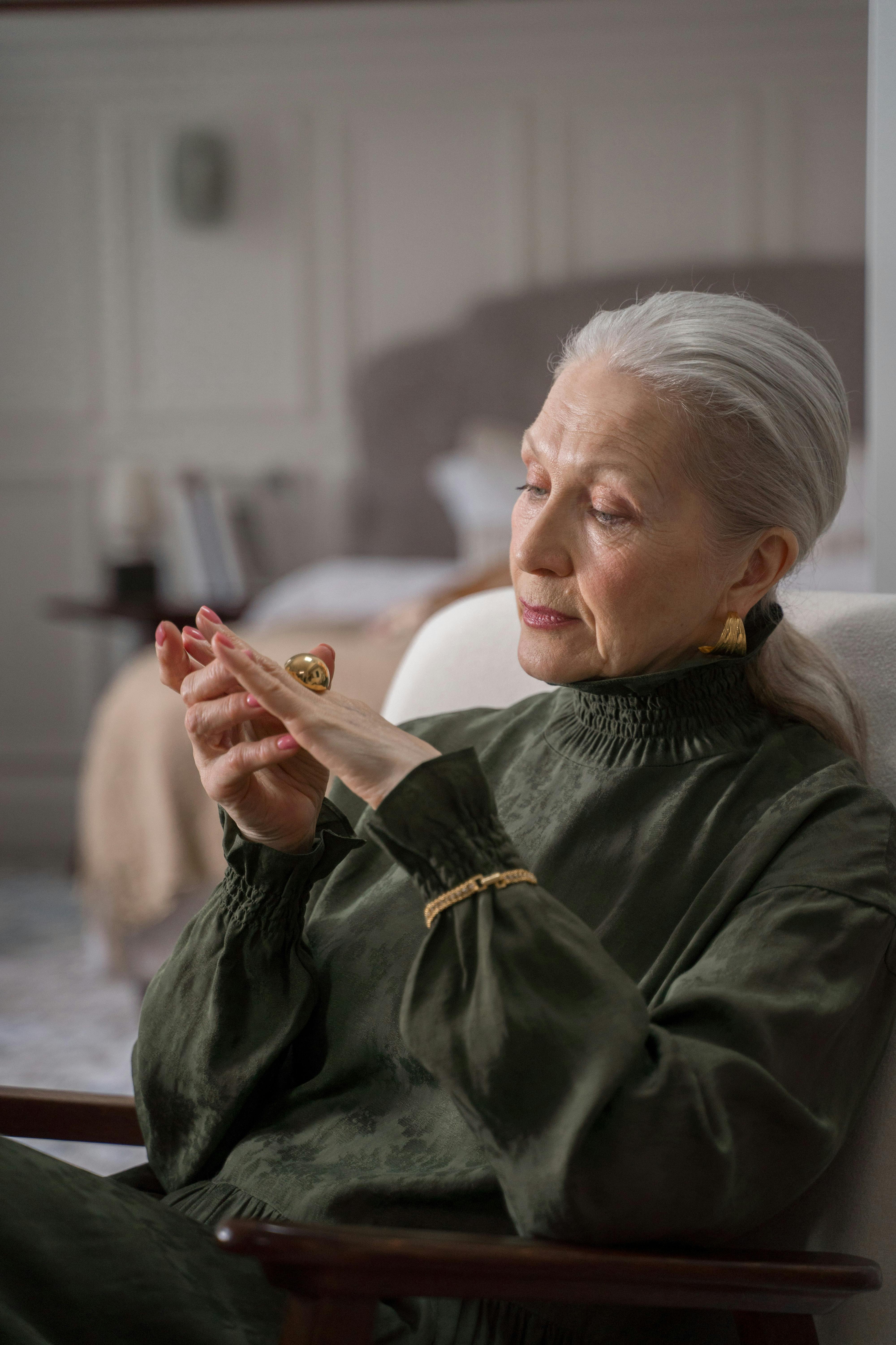 elderly woman looking at her gold ring