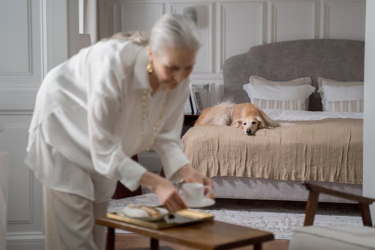 Elderly Woman Laying A Cup On The Table