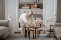 Elderly Woman Putting on the Table a Cup