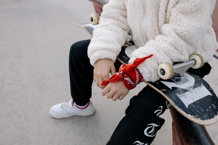 Teenager Sitting With Skateboard