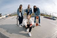 Group of Teenage Girls Wearing Jackets Posing and Standing on Skate Park