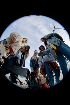 Young women skaters captured through a fisheye lens showcasing friendship and teamwork outdoors.