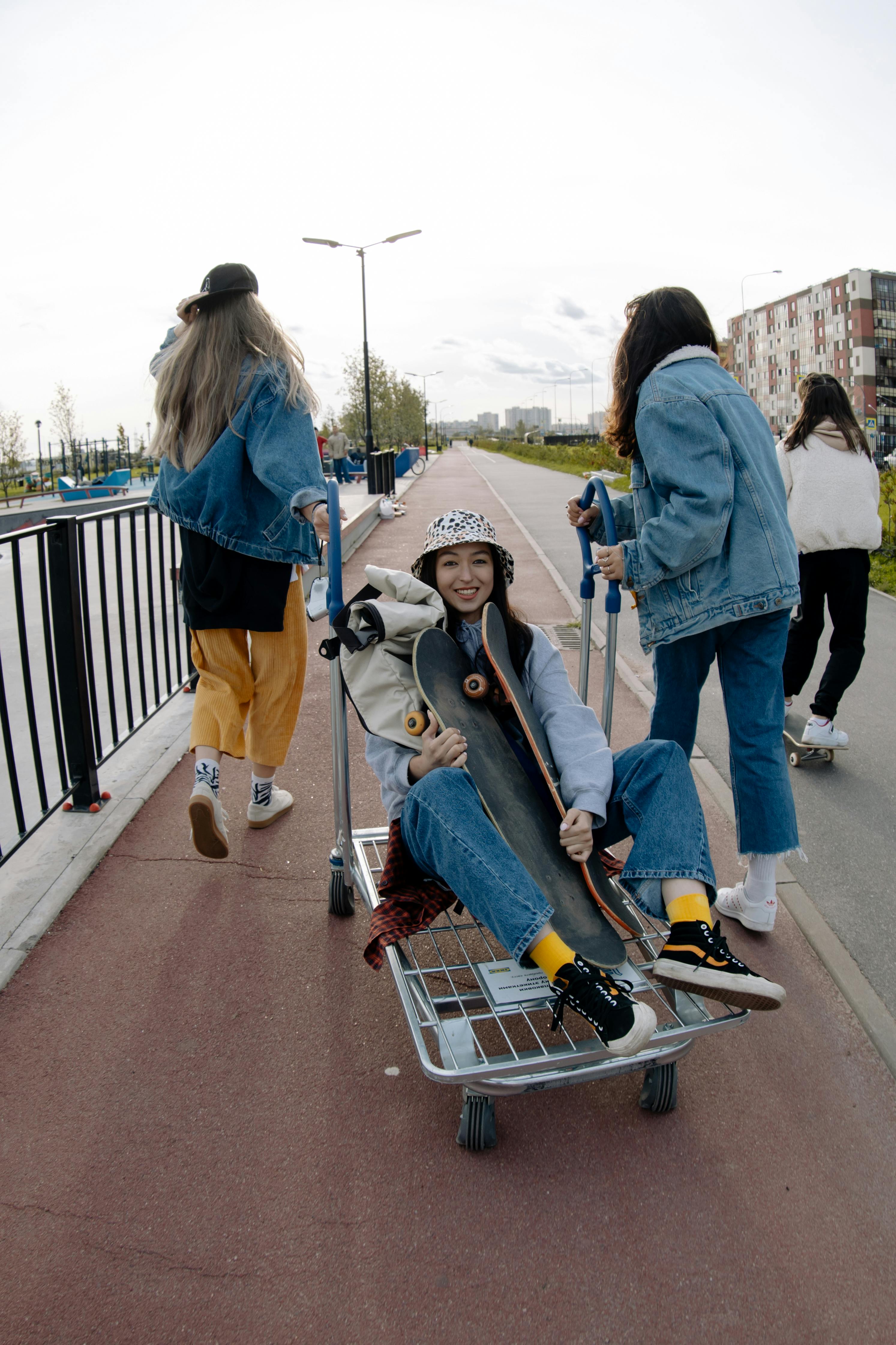 young girl riding on trolley holding longboards