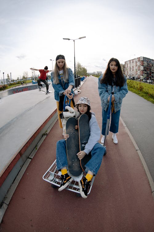 Free Teenage Girls in Denim Jacket Holding Skateboard on Skate Park Stock Photo