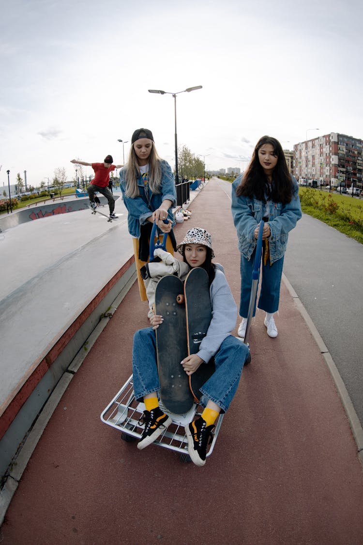 Teenage Girls In Denim Jacket Holding Skateboard On Skate Park