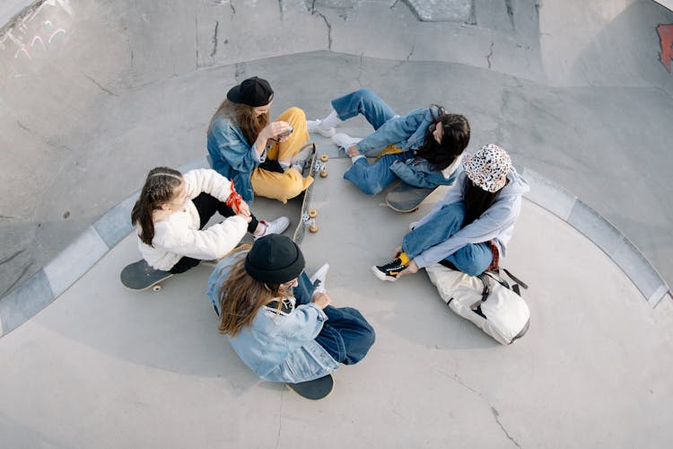 Group Of People Sitting On Pavement