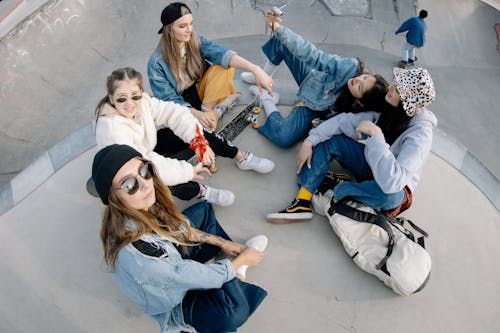 Free Group of Friends Having Fun Sitting on Skate Park Stock Photo